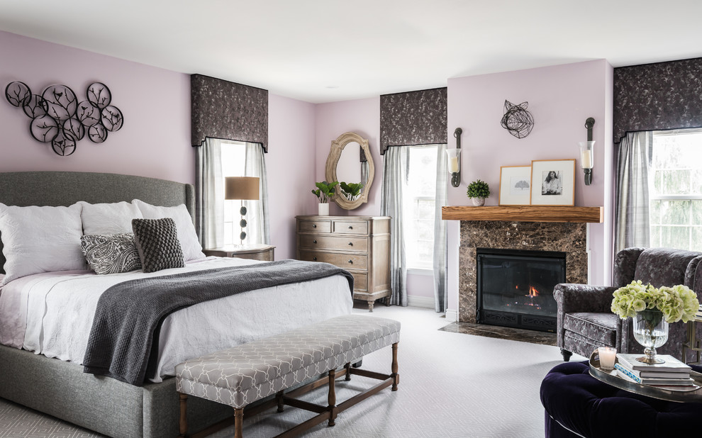 Photo of a large transitional master bedroom in St Louis with carpet, a standard fireplace, a stone fireplace surround, grey floor and pink walls.