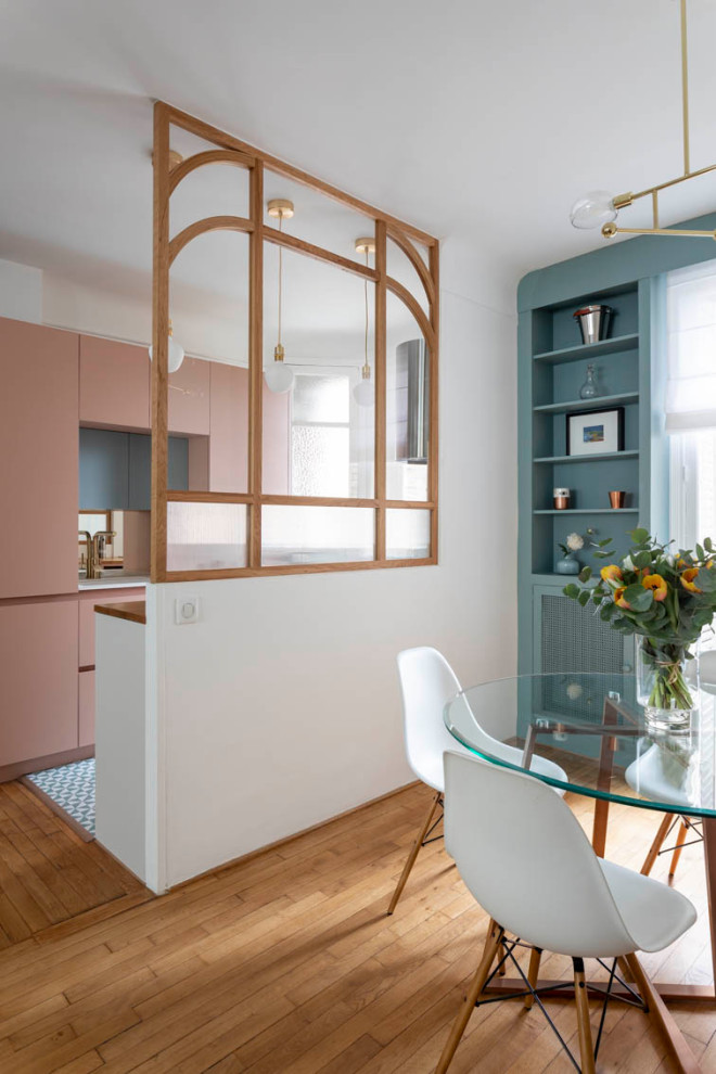 Inspiration for a small classic galley kitchen/diner in Paris with a submerged sink, pink cabinets, wood worktops, mirror splashback, stainless steel appliances and light hardwood flooring.
