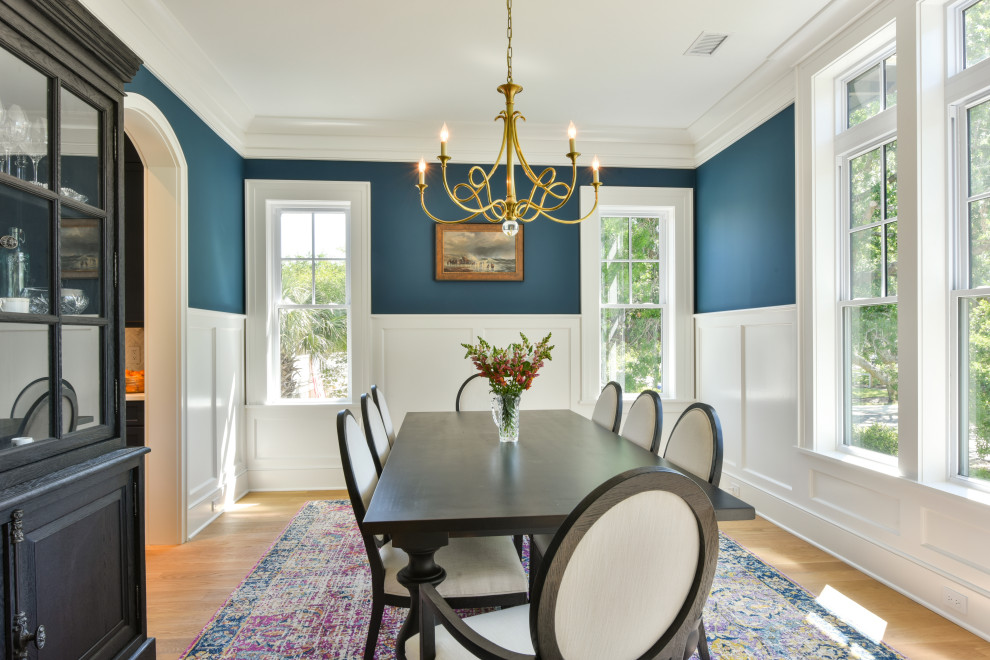 Design ideas for a beach style separate dining room in Charleston with blue walls, light hardwood floors and decorative wall panelling.