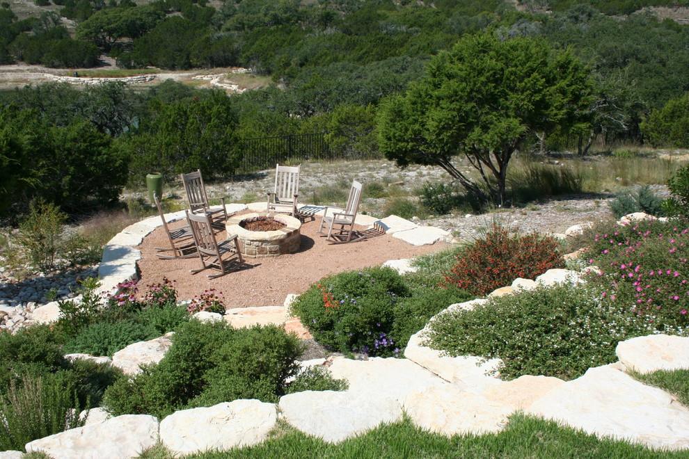 Design ideas for a large rustic full sun backyard stone landscaping in Austin with a fire pit for summer.