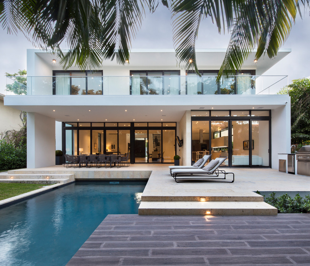 Inspiration for a contemporary two-storey white house exterior in Miami with a flat roof.