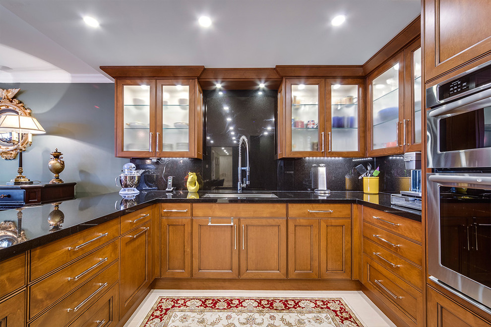 Example of a mid-sized transitional u-shaped eat-in kitchen design in Phoenix with an undermount sink, medium tone wood cabinets, granite countertops, black backsplash, stainless steel appliances and a peninsula