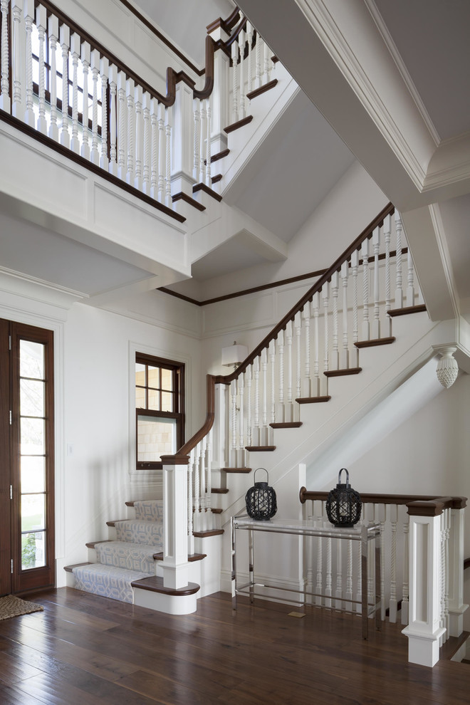 This is an example of a traditional wood u-shaped staircase in Boston with painted wood risers.