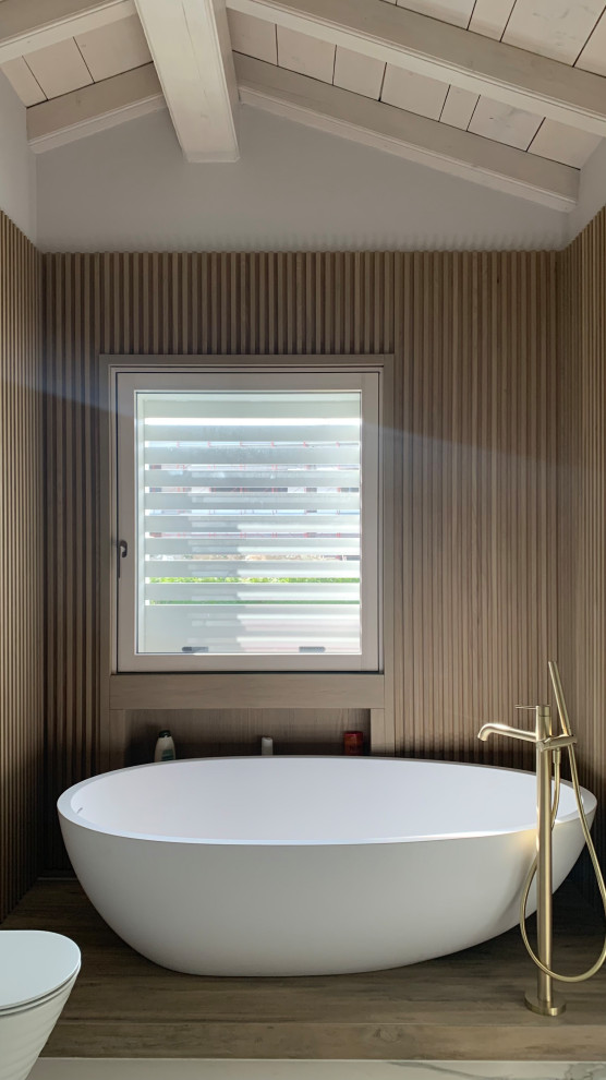 Свежая идея для дизайна: маленькая ванная комната в современном стиле с стеклянными фасадами, бежевыми фасадами, отдельно стоящей ванной, душем без бортиков, инсталляцией, белой плиткой, керамогранитной плиткой, бежевыми стенами, полом из керамогранита, душевой кабиной, монолитной раковиной, мраморной столешницей, белым полом, душем с распашными дверями, коричневой столешницей, сиденьем для душа, тумбой под одну раковину, подвесной тумбой, балками на потолке и панелями на стенах для на участке и в саду - отличное фото интерьера