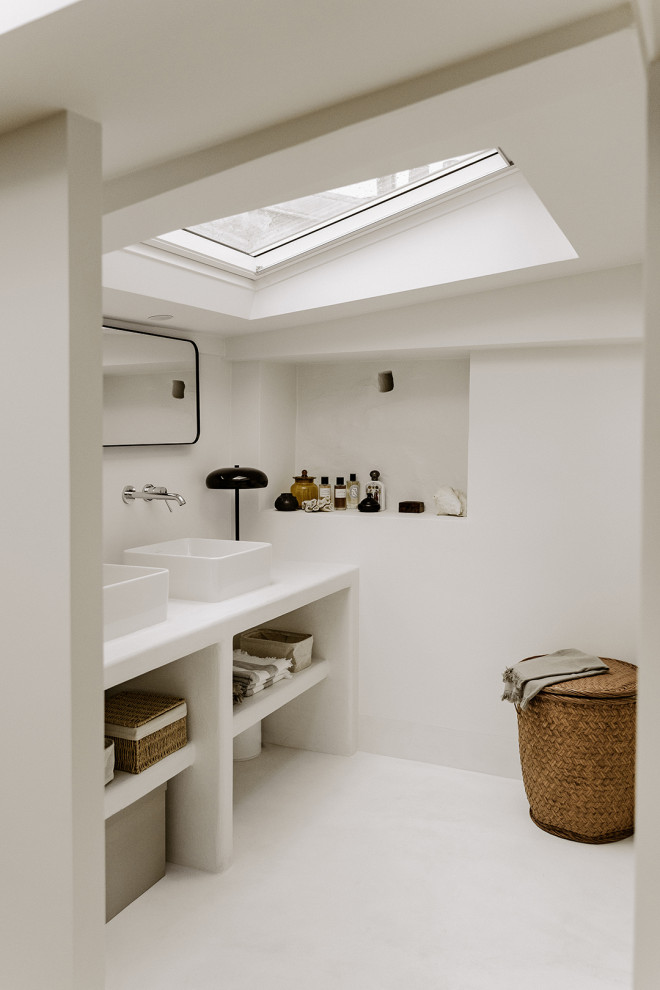Design ideas for a mid-sized mediterranean 3/4 bathroom in Paris with open cabinets, a curbless shower, a two-piece toilet, white walls, concrete floors, a drop-in sink, concrete benchtops, white floor, a hinged shower door, white benchtops, a shower seat and a double vanity.