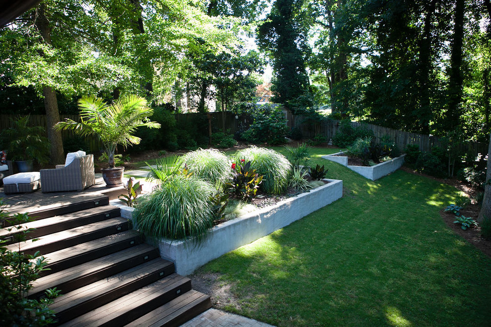 Inspiration for a mid-sized contemporary backyard partial sun xeriscape for summer in Atlanta with a retaining wall and decking.
