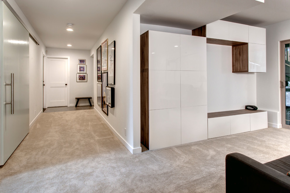Photo of a contemporary walk-out basement in Seattle with white walls, carpet, a standard fireplace and a tile fireplace surround.