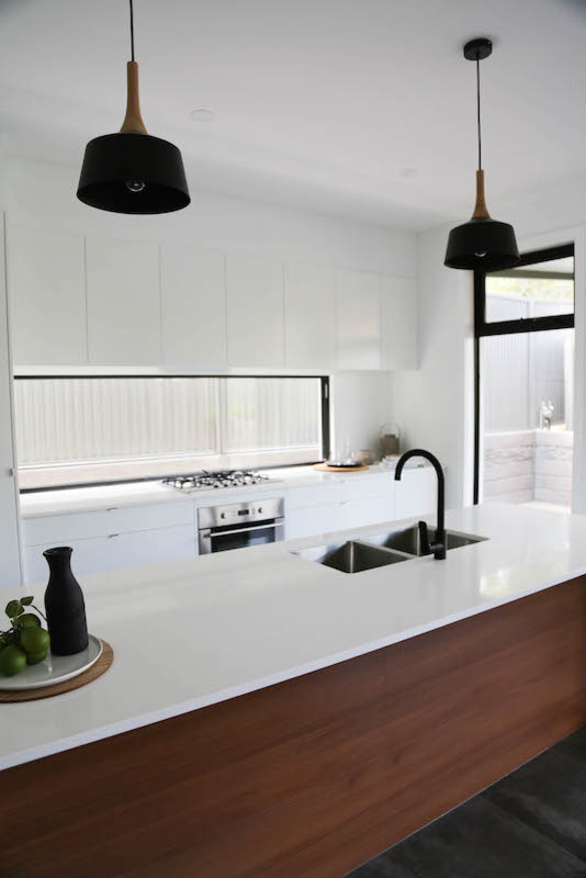 Design ideas for a mid-sized contemporary galley eat-in kitchen in Adelaide with recessed-panel cabinets, white cabinets, limestone benchtops, glass sheet splashback, stainless steel appliances and with island.