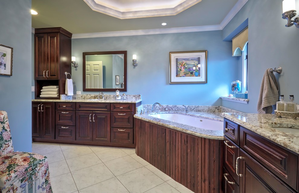 Bathroom - large transitional master ceramic tile and beige floor bathroom idea in Chicago with raised-panel cabinets, dark wood cabinets, an undermount tub, blue walls, an undermount sink and granite countertops