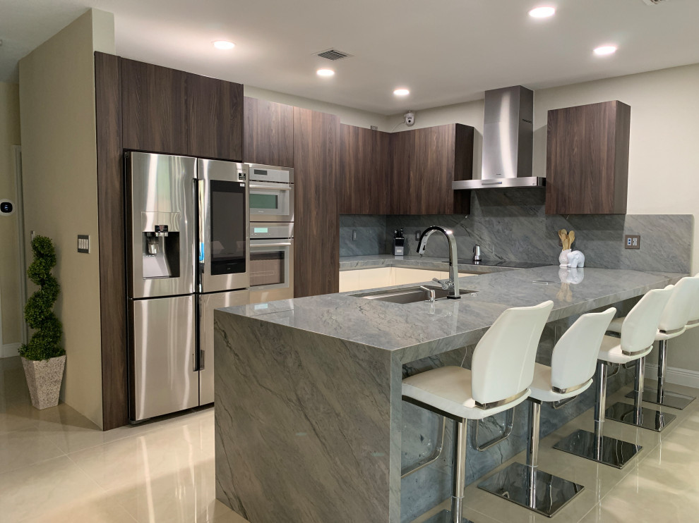 Design ideas for a small modern u-shaped eat-in kitchen in Miami with an undermount sink, flat-panel cabinets, dark wood cabinets, granite benchtops, grey splashback, granite splashback, stainless steel appliances, travertine floors, with island, beige floor and grey benchtop.