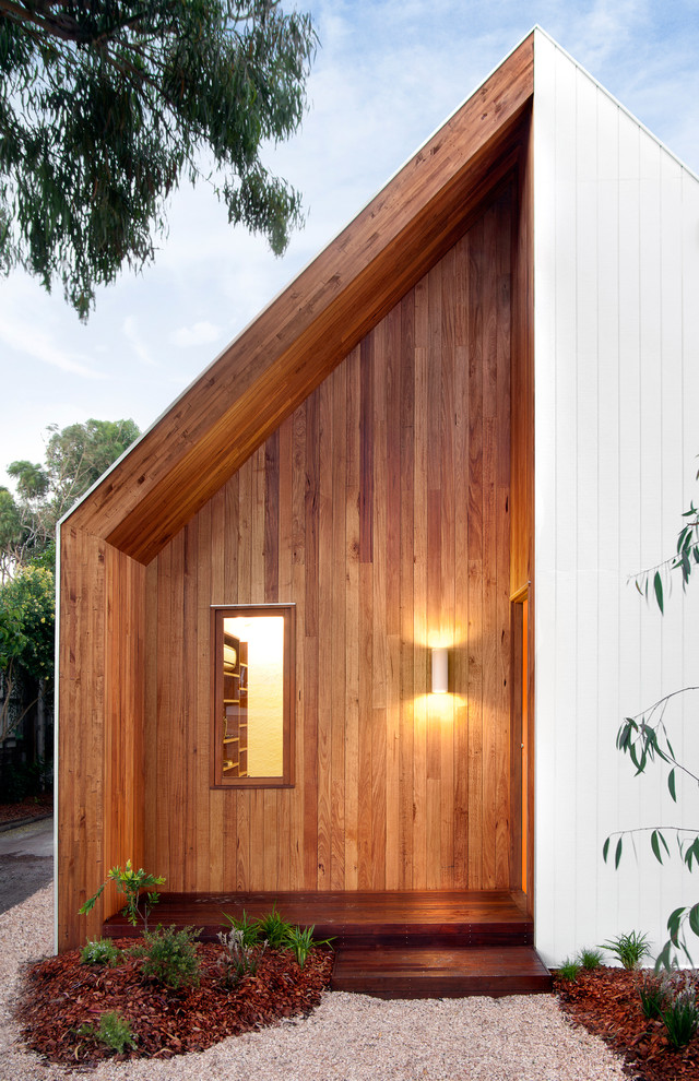 This is an example of a contemporary front door in Melbourne with an orange front door.