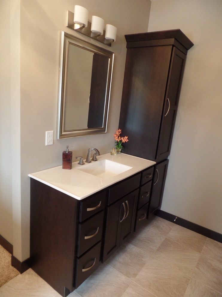 Mid-sized transitional 3/4 porcelain tile and beige floor bathroom photo in Cedar Rapids with shaker cabinets, dark wood cabinets, a two-piece toilet, beige walls, an integrated sink and quartz countertops