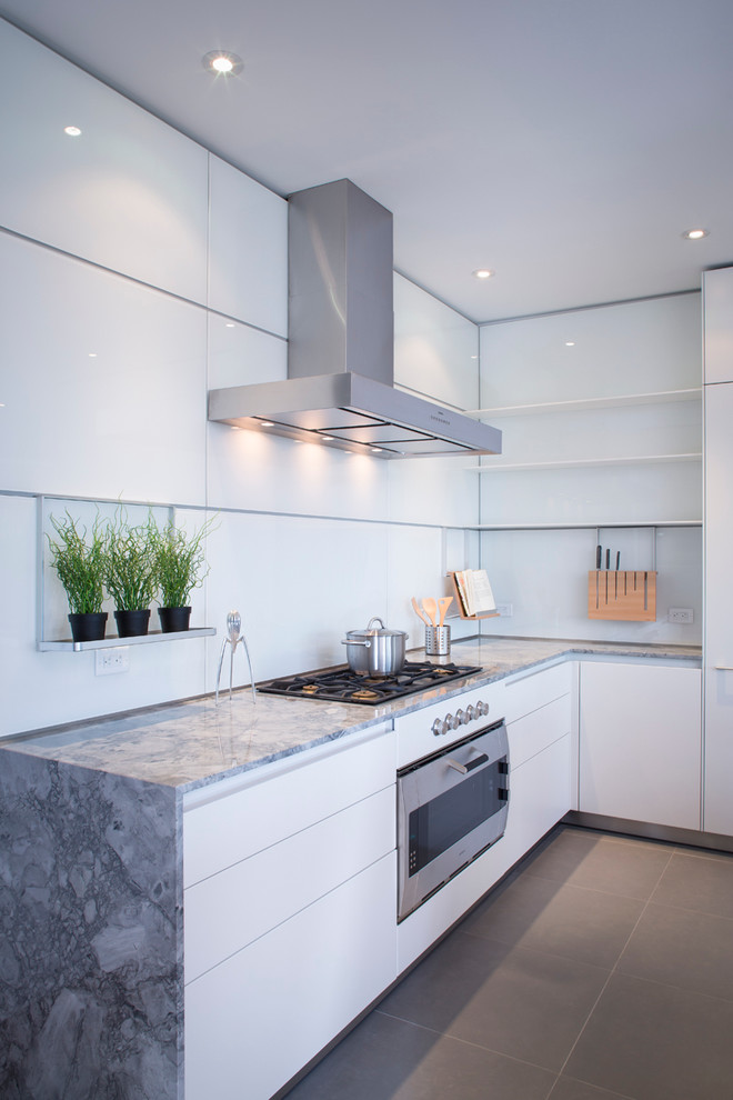 Inspiration for a mid-sized modern u-shaped separate kitchen in Calgary with an undermount sink, flat-panel cabinets, white cabinets, granite benchtops, white splashback, glass sheet splashback, stainless steel appliances, porcelain floors and with island.