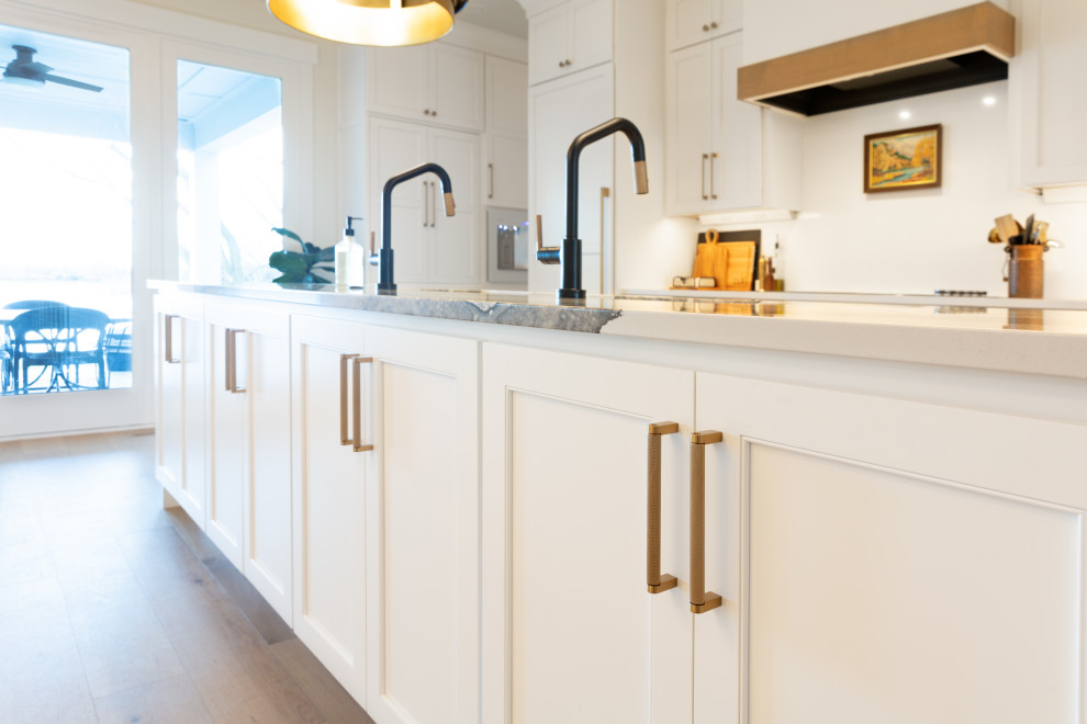 Design ideas for a large traditional kitchen/diner in Other with white cabinets, engineered stone countertops, white splashback, engineered quartz splashback, integrated appliances, multiple islands, white worktops and shaker cabinets.