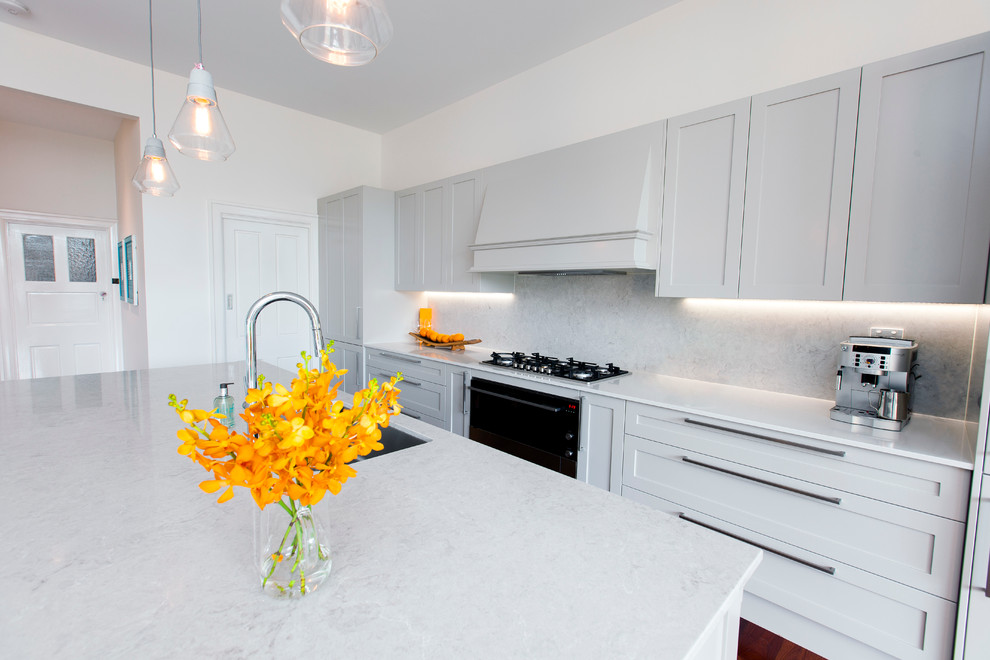Design ideas for a large contemporary galley eat-in kitchen in Adelaide with an undermount sink, shaker cabinets, grey cabinets, quartz benchtops, grey splashback, stone slab splashback, black appliances, dark hardwood floors and with island.