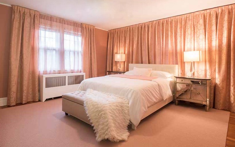 Photo of a mid-sized transitional master bedroom in New York with pink walls and carpet.