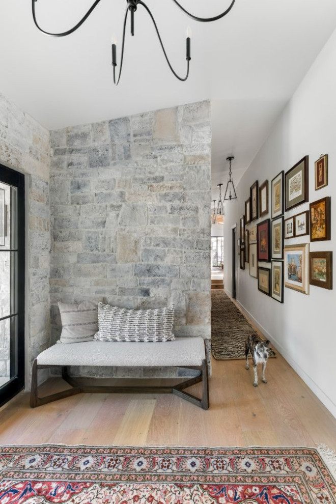 Ejemplo de entrada de estilo de casa de campo de tamaño medio con paredes blancas y suelo de madera en tonos medios