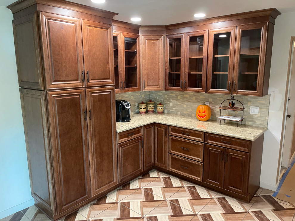 Idées déco pour une cuisine américaine parallèle classique en bois brun de taille moyenne avec un placard avec porte à panneau surélevé, un plan de travail en quartz modifié et une crédence en mosaïque.