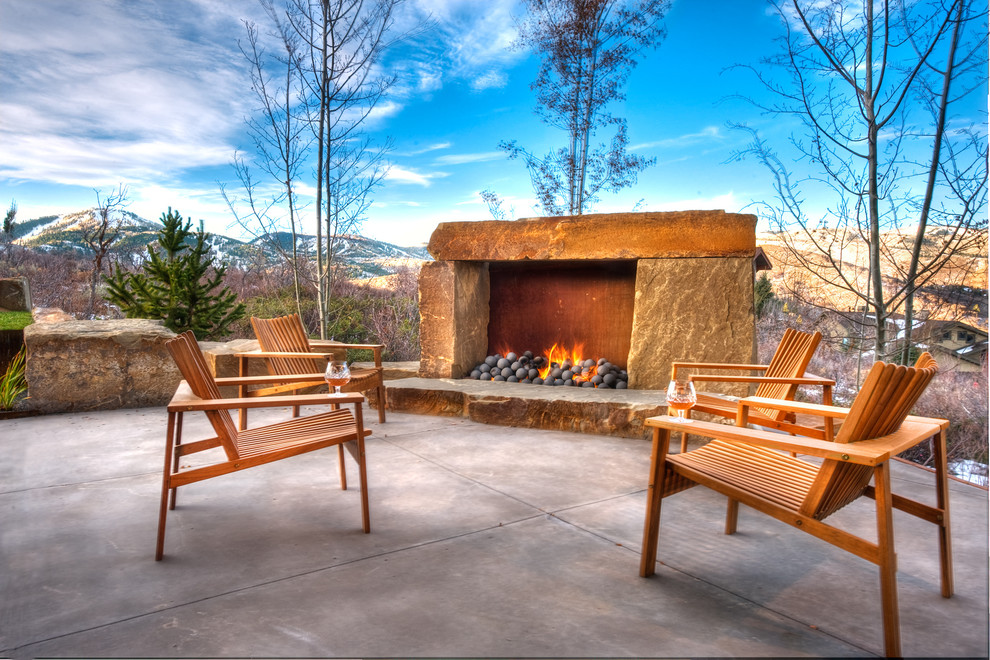 Inspiration for a mid-sized country backyard patio in Salt Lake City with concrete slab, no cover and with fireplace.