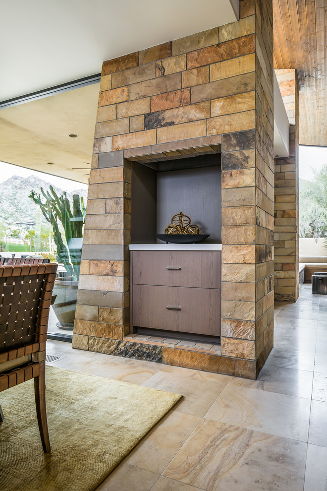 Photo of a large contemporary open plan dining in Phoenix with multi-coloured walls, travertine floors, a two-sided fireplace, a wood fireplace surround and beige floor.