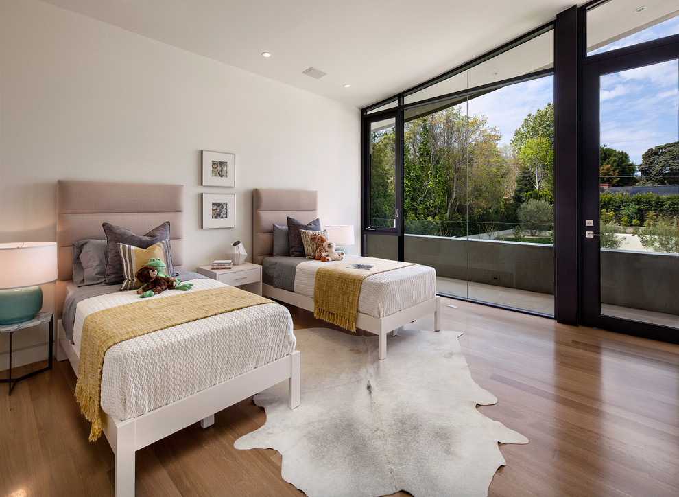 Inspiration for a large contemporary gender-neutral medium tone wood floor and brown floor kids' room remodel in Los Angeles with white walls