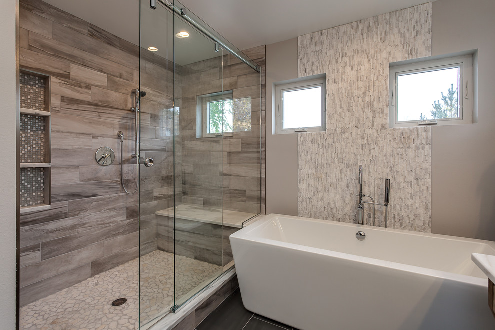 This is an example of an expansive contemporary master bathroom in Denver with flat-panel cabinets, a freestanding tub, an open shower, beige tile, ceramic tile, grey walls, an undermount sink and granite benchtops.