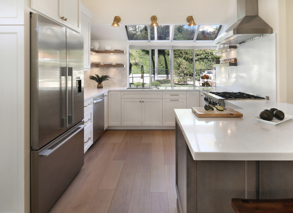 Photo of a large transitional u-shaped eat-in kitchen in Orange County with an undermount sink, recessed-panel cabinets, white cabinets, quartz benchtops, multi-coloured splashback, engineered quartz splashback, stainless steel appliances, a peninsula, beige floor and yellow benchtop.