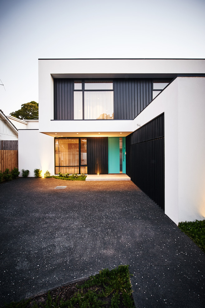 Inspiration for a mid-sized contemporary two-storey white house exterior in Melbourne with metal siding, a flat roof and a shingle roof.