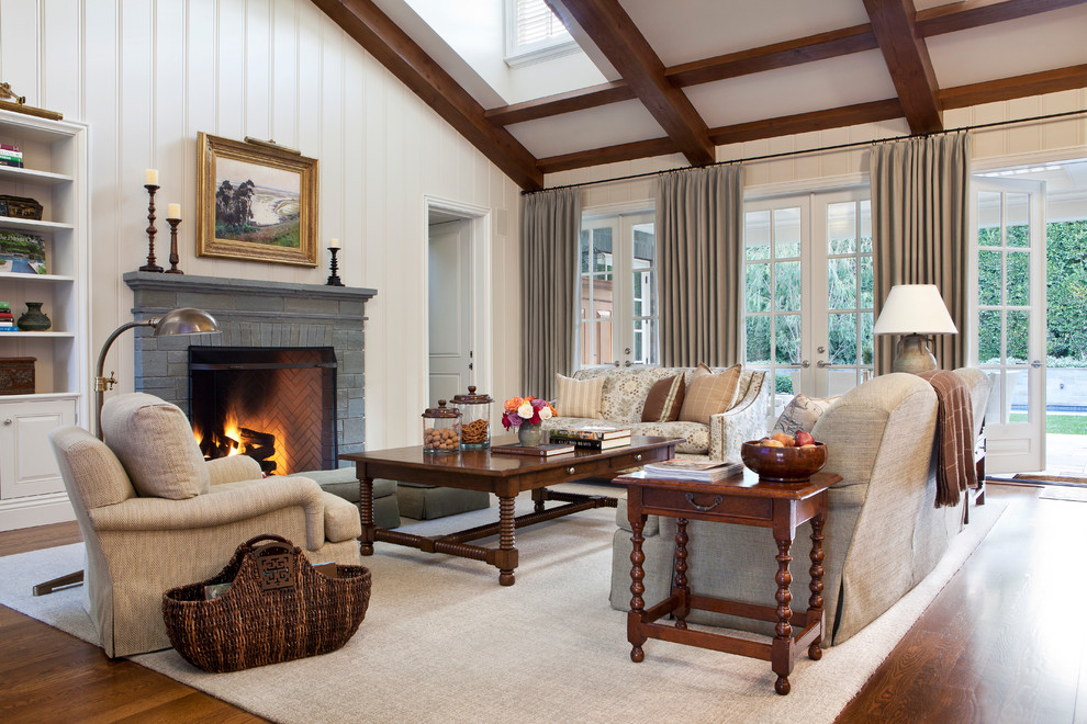 Inspiration for a large traditional formal open concept living room in Los Angeles with medium hardwood floors, a standard fireplace, white walls, a stone fireplace surround and brown floor.