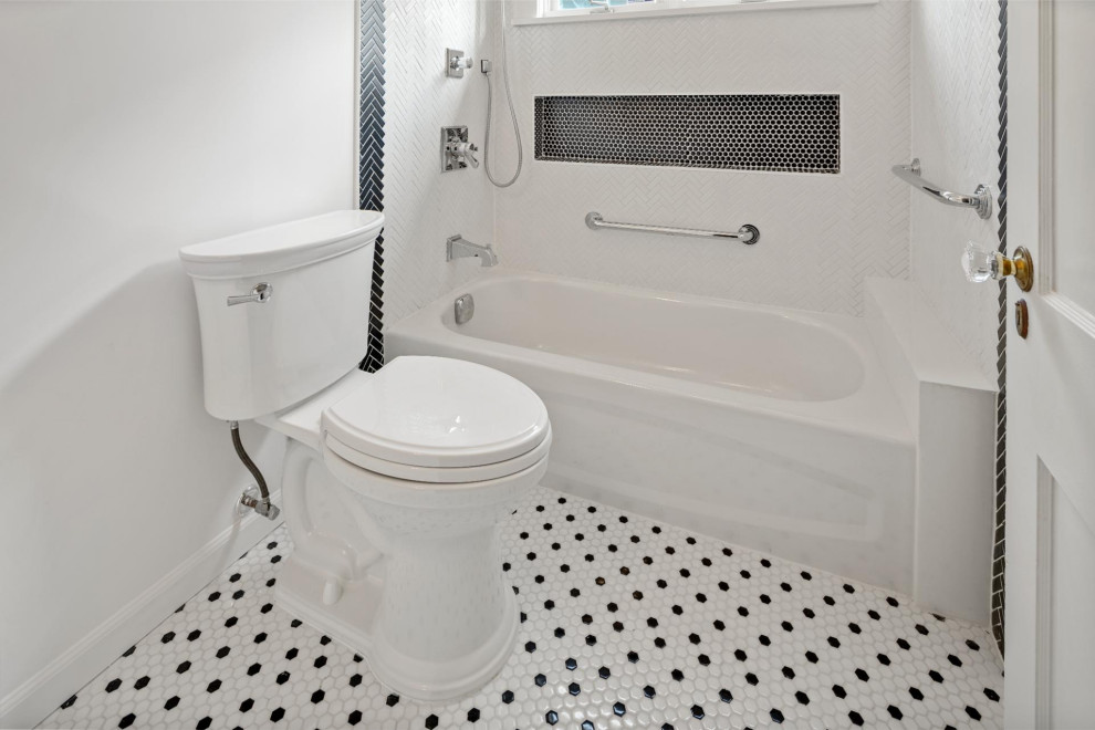 Bild på ett svart svart badrum, med vita skåp, ett fristående badkar, en dusch/badkar-kombination, en toalettstol med hel cisternkåpa, vit kakel, keramikplattor, vita väggar, mosaikgolv, flerfärgat golv och dusch med duschdraperi