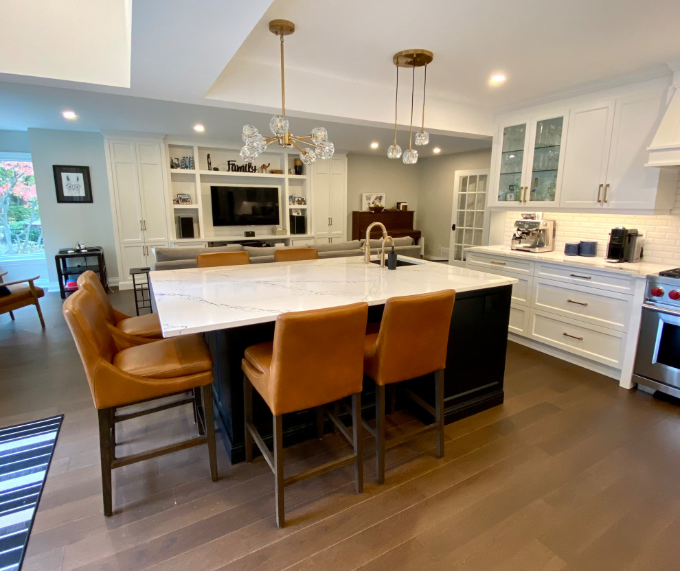 Example of a large transitional medium tone wood floor kitchen design in Toronto with an undermount sink, recessed-panel cabinets, white cabinets, quartz countertops, white backsplash, porcelain backsplash, paneled appliances, two islands and white countertops