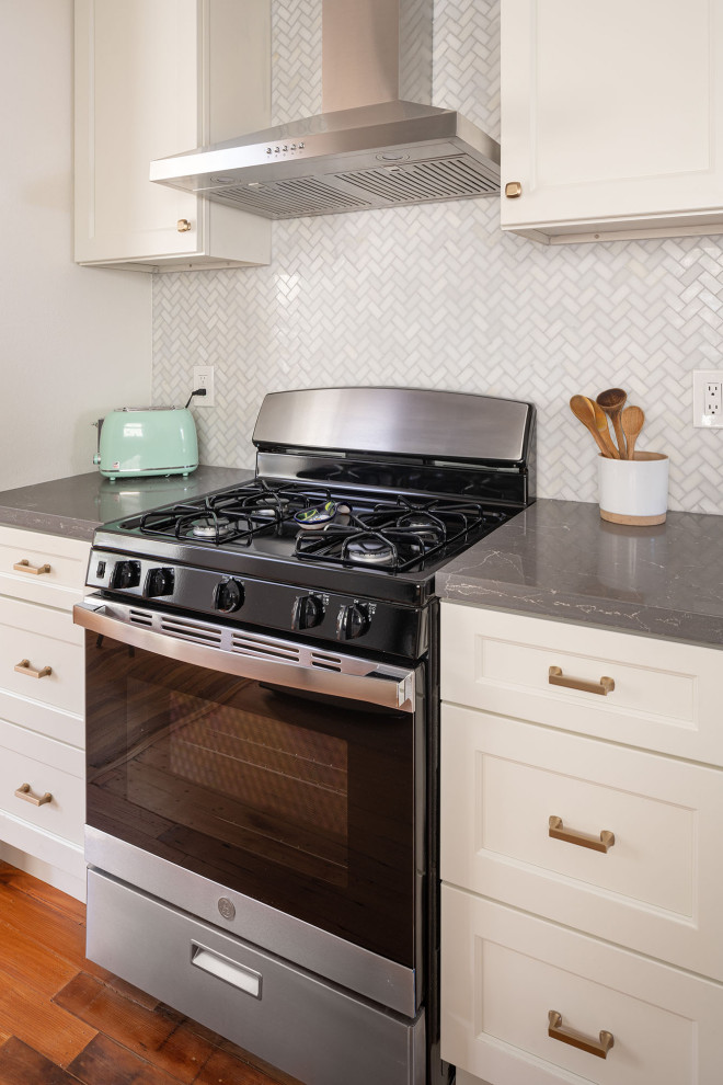 Idéer för att renovera ett litet medelhavsstil grå grått kök, med en undermonterad diskho, skåp i shakerstil, vita skåp, bänkskiva i kvartsit, vitt stänkskydd, stänkskydd i marmor, rostfria vitvaror, mellanmörkt trägolv och brunt golv