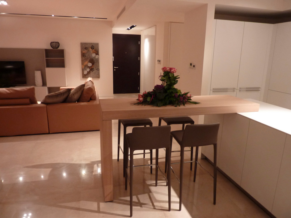 This is an example of an expansive modern u-shaped open plan kitchen in Other with a double-bowl sink, flat-panel cabinets, white cabinets, laminate benchtops, white splashback, window splashback, stainless steel appliances, marble floors, with island, beige floor, white benchtop and recessed.