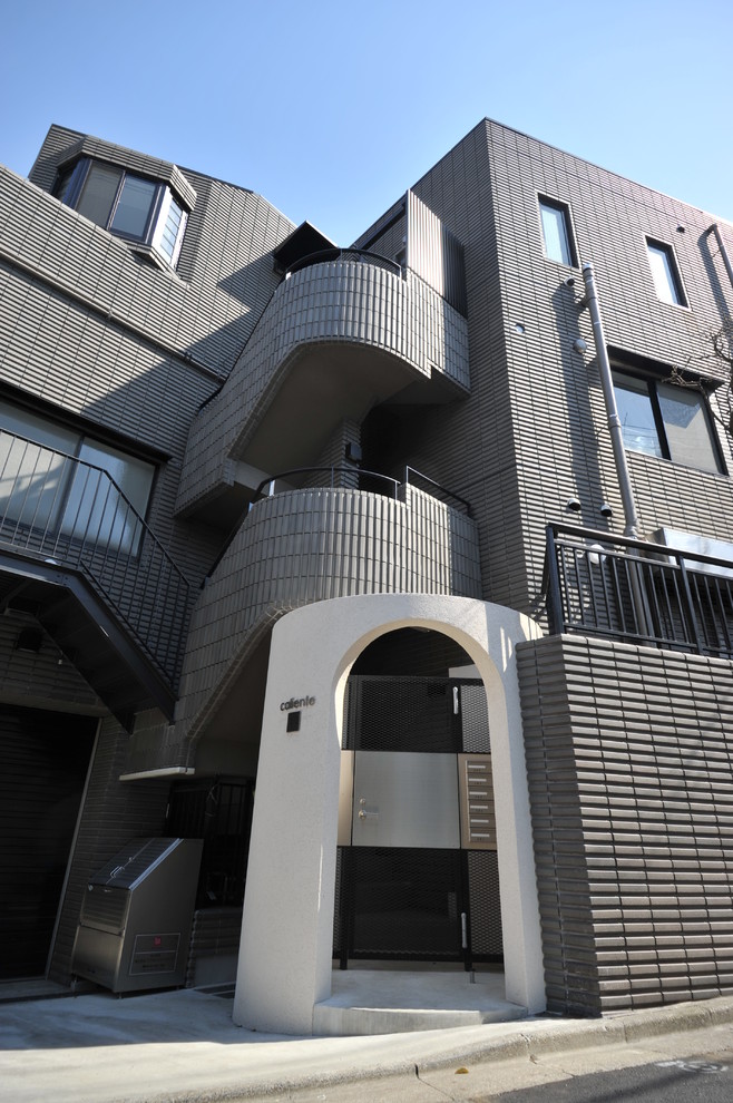 Mid-sized contemporary three-storey brown apartment exterior in Tokyo with a flat roof.