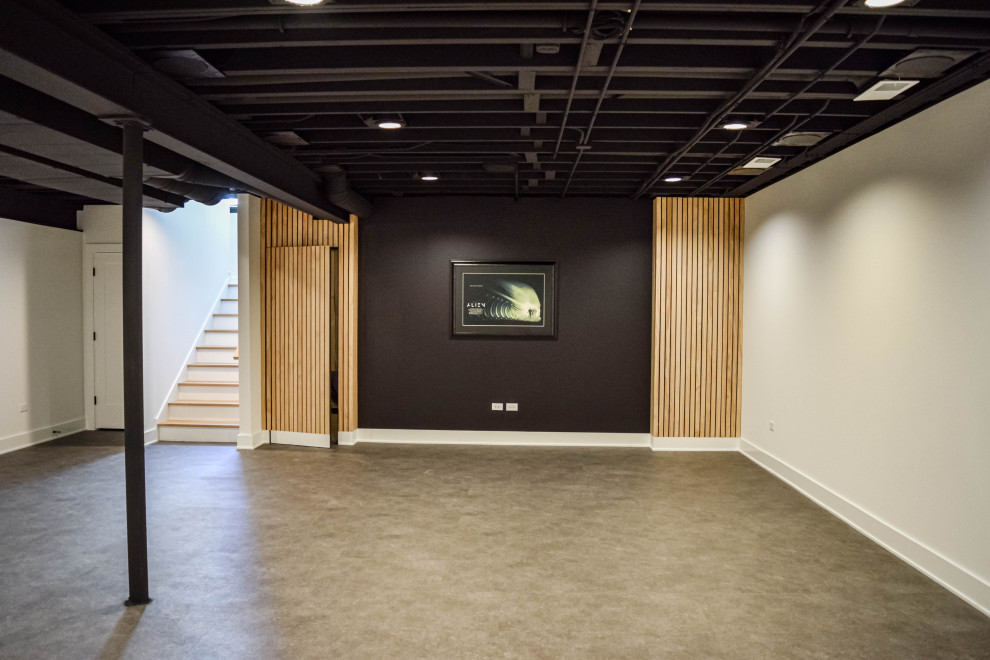 Modern fully buried basement in Chicago with black walls, laminate floors and black floor.