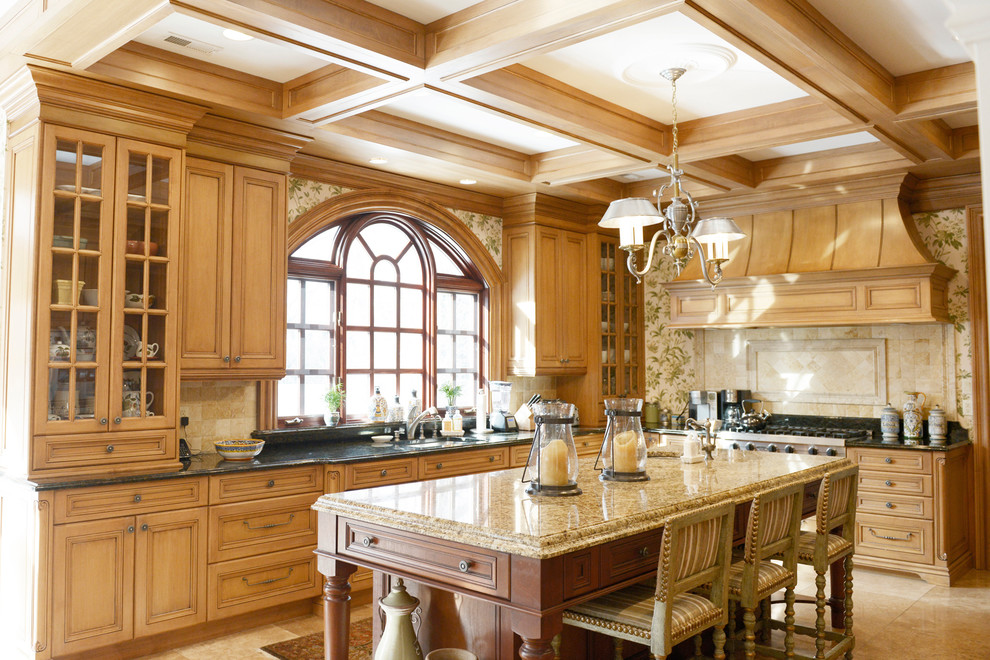 This is an example of a traditional l-shaped kitchen in New York with raised-panel cabinets, medium wood cabinets, beige splashback, stainless steel appliances and with island.
