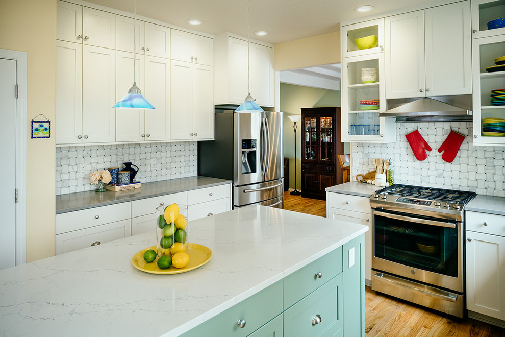 Example of a transitional medium tone wood floor eat-in kitchen design with an undermount sink, shaker cabinets, white cabinets, quartzite countertops, gray backsplash, stainless steel appliances, an island and gray countertops
