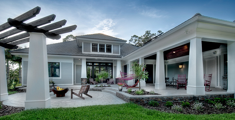Photo of a large arts and crafts one-storey grey exterior in Miami with mixed siding.