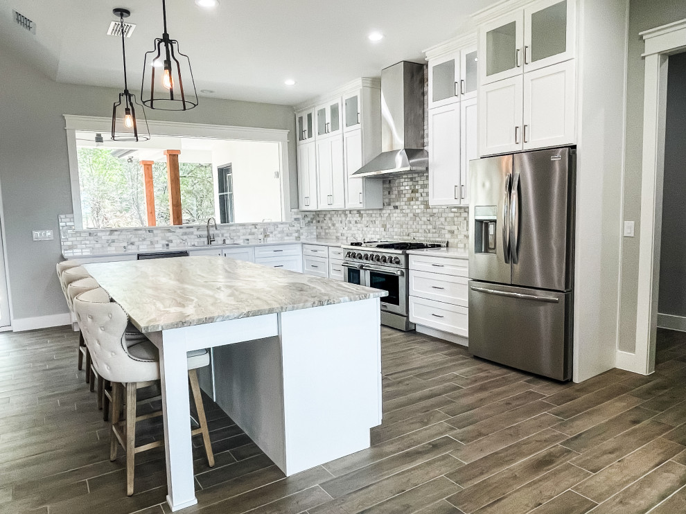 Eat-in kitchen - large transitional l-shaped medium tone wood floor and brown floor eat-in kitchen idea with an undermount sink, beaded inset cabinets, white cabinets, marble countertops, multicolored backsplash, ceramic backsplash, stainless steel appliances, an island and multicolored countertops