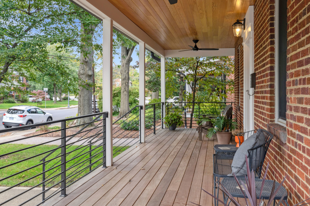Large transitional front yard verandah in DC Metro with with columns, decking, a roof extension and metal railing.