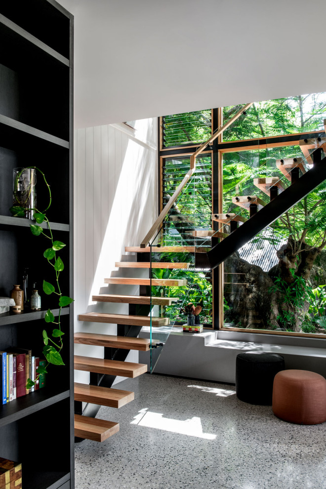 Mid-sized contemporary wood l-shaped staircase in Brisbane with glass railing and open risers.