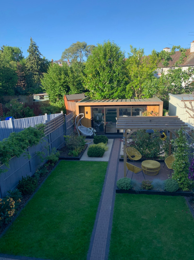 Diseño de jardín de secano actual de tamaño medio en otoño en patio trasero con pérgola, exposición total al sol, adoquines de ladrillo y con madera