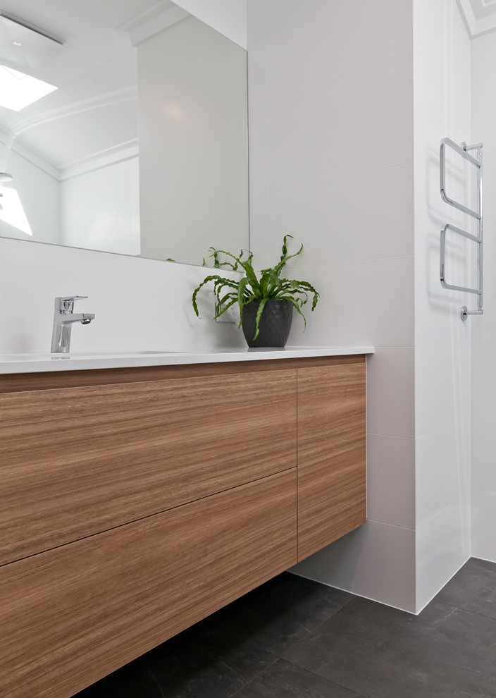 Design ideas for a mid-sized contemporary 3/4 bathroom in Perth with flat-panel cabinets, medium wood cabinets, an open shower, a two-piece toilet, gray tile, porcelain tile, white walls, porcelain floors, an undermount sink, engineered quartz benchtops, grey floor, an open shower and white benchtops.