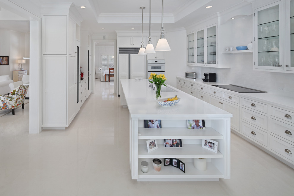 This is an example of a transitional kitchen in Miami with glass-front cabinets, white cabinets and panelled appliances.