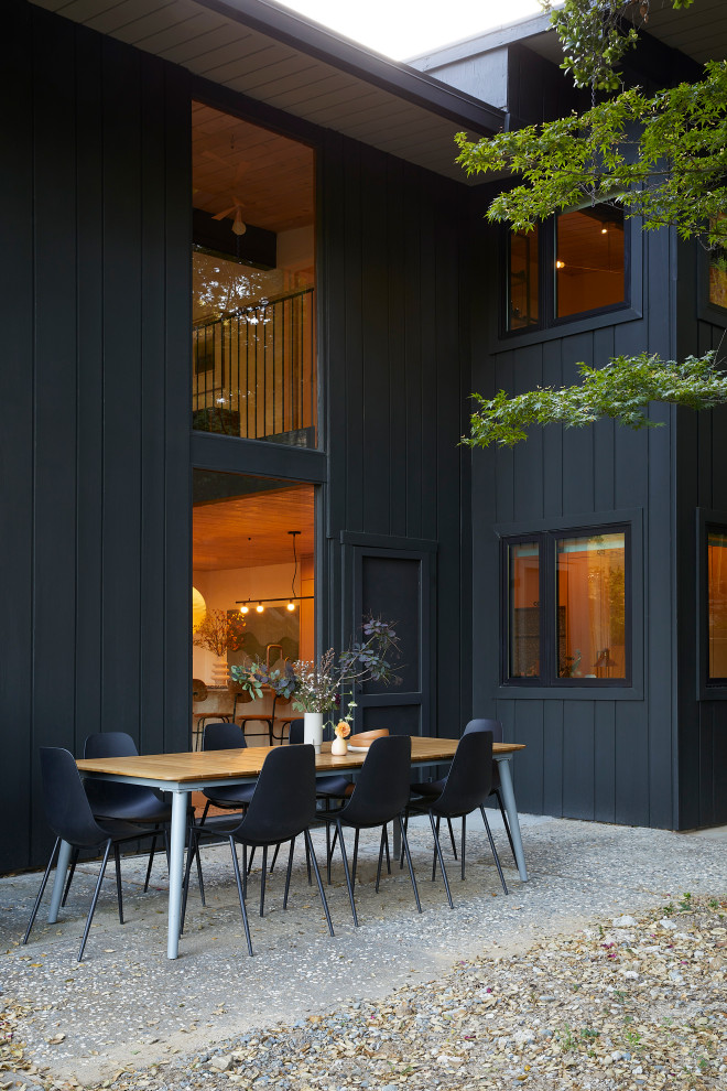 This is an example of a medium sized and black retro two floor detached house in San Francisco with wood cladding and a flat roof.