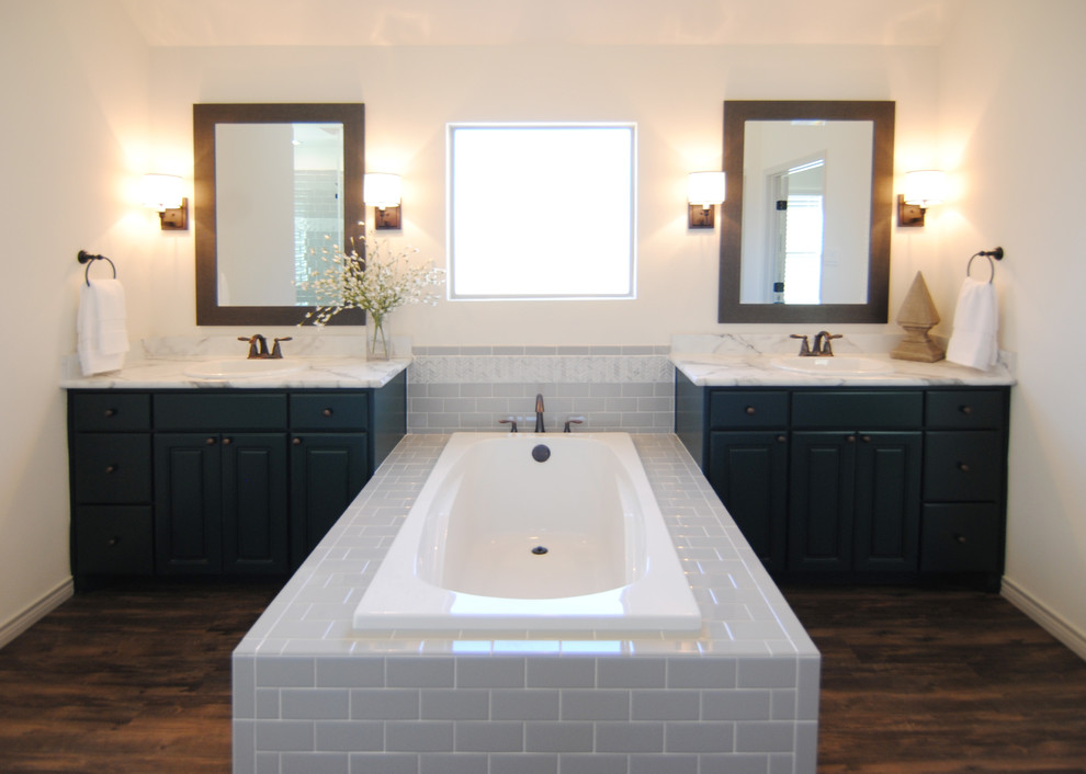 Design ideas for a large country master bathroom in Austin with raised-panel cabinets, green cabinets, a drop-in tub, an alcove shower, a two-piece toilet, gray tile, subway tile, white walls, vinyl floors, a drop-in sink and laminate benchtops.