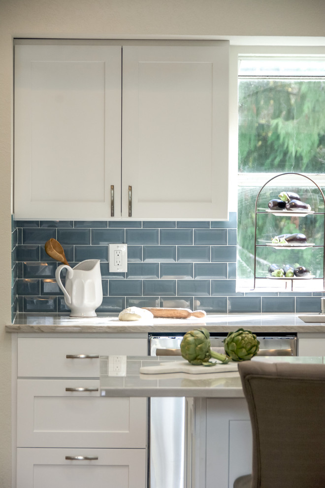 Open concept kitchen - large transitional galley medium tone wood floor and brown floor open concept kitchen idea in Seattle with an undermount sink, shaker cabinets, white cabinets, quartz countertops, blue backsplash, subway tile backsplash, stainless steel appliances, an island and multicolored countertops