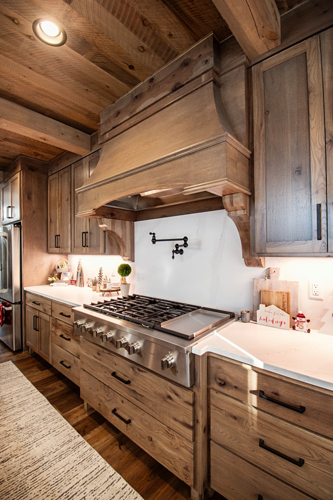 Example of a large mountain style single-wall medium tone wood floor, multicolored floor and coffered ceiling eat-in kitchen design with flat-panel cabinets, medium tone wood cabinets, quartzite countertops, multicolored backsplash, granite backsplash, stainless steel appliances, an island and multicolored countertops