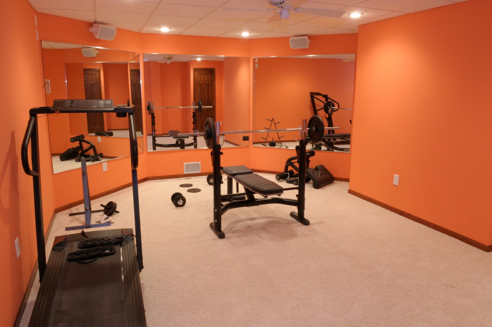 Inspiration for a mid-sized transitional home weight room in Other with orange walls, carpet and beige floor.