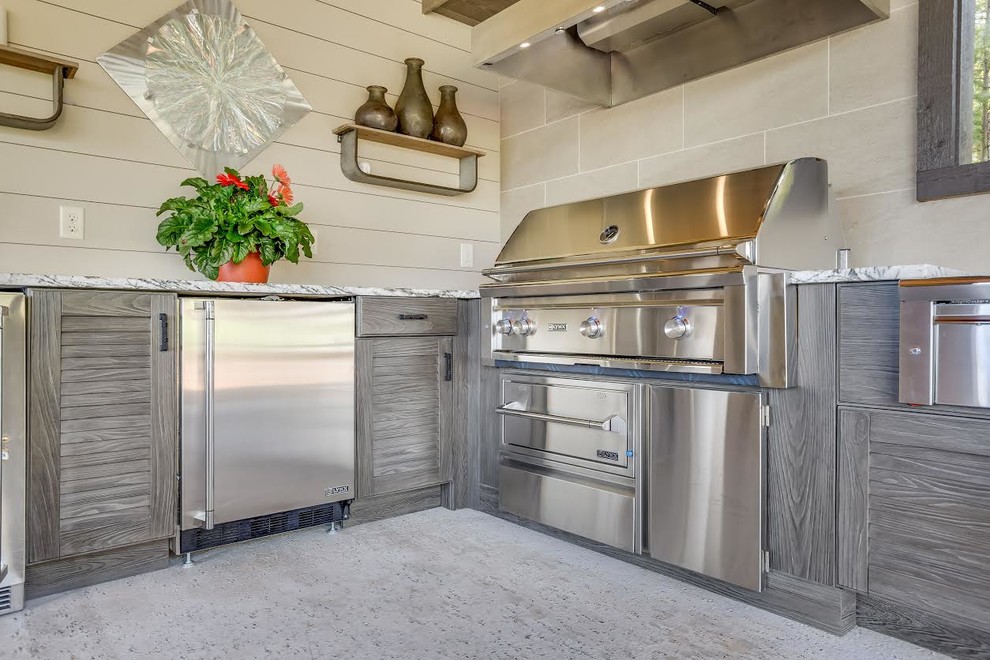 Expansive contemporary l-shaped kitchen in Birmingham with a farmhouse sink, louvered cabinets, distressed cabinets, granite benchtops, stainless steel appliances and concrete floors.
